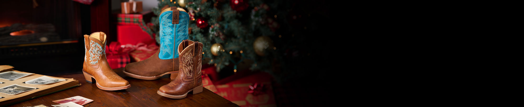 Canter Junior in Amber Brown, Jackpot 11" Western in brown, and Isabella 7” in tan cowboy boots posed on a table with a Christmas scene behind them.